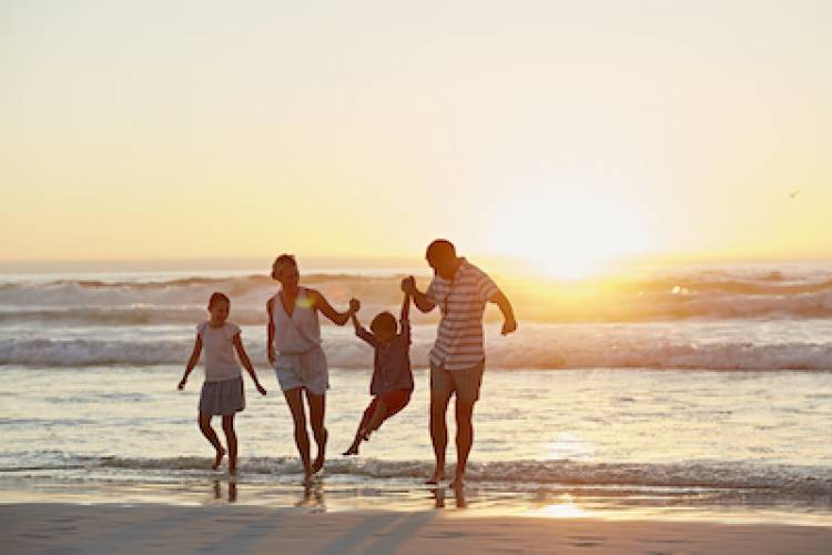 family on beach at sunset