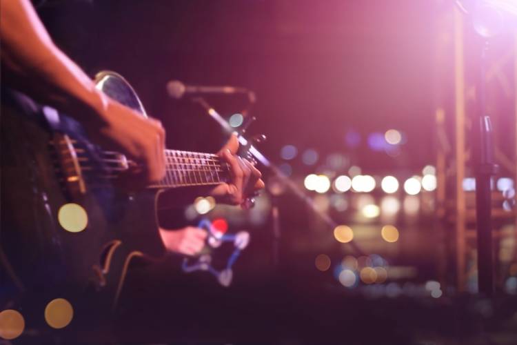 person on stage playing guitar